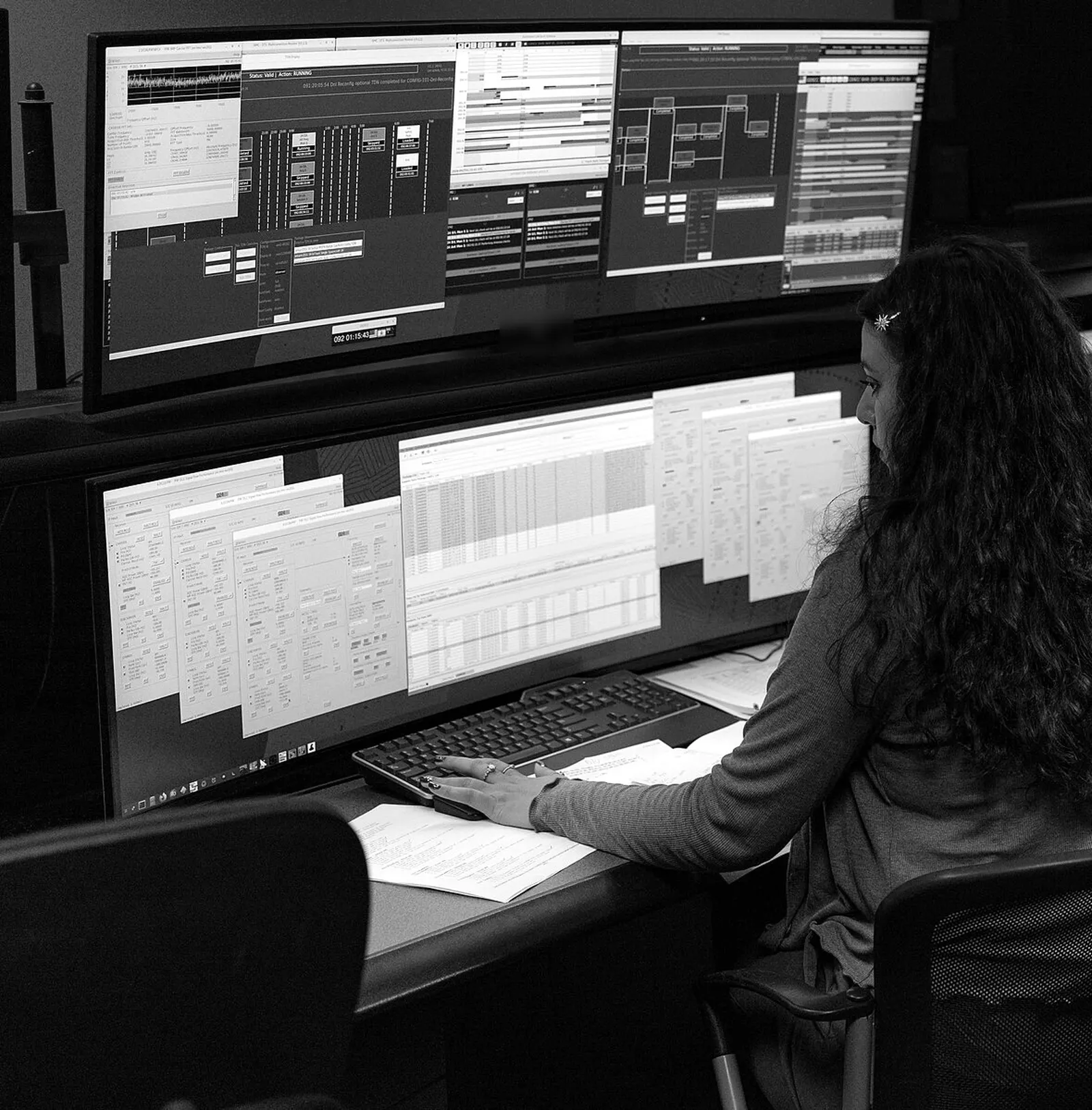 Operadora revisando pantallas de monitoreo en una sala de control